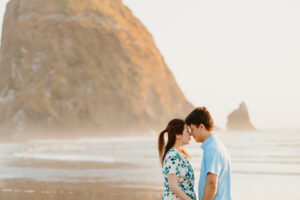 A man and a woman on cannon beach in front of haystack rock