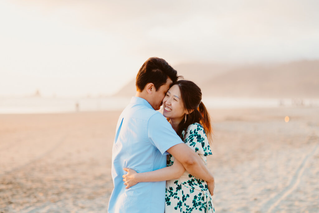 Cannon beach oregon maternity session with couple on beach in front of haystack rock